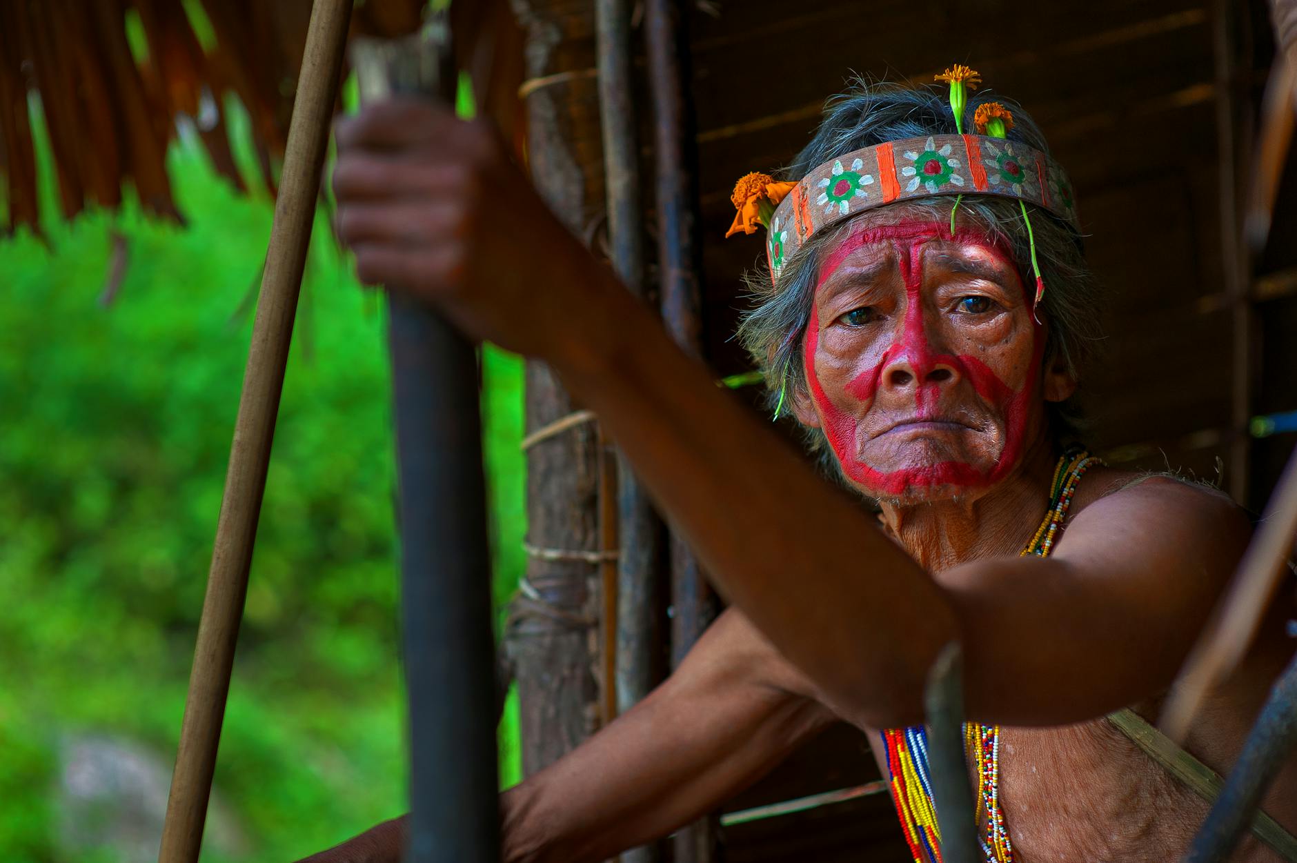 selective focus photography of man holding stick wearing headband